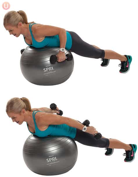 Chris Freytag doing tricep kickbacks with dumbbells, lying on a silver/ grey stability ball. 